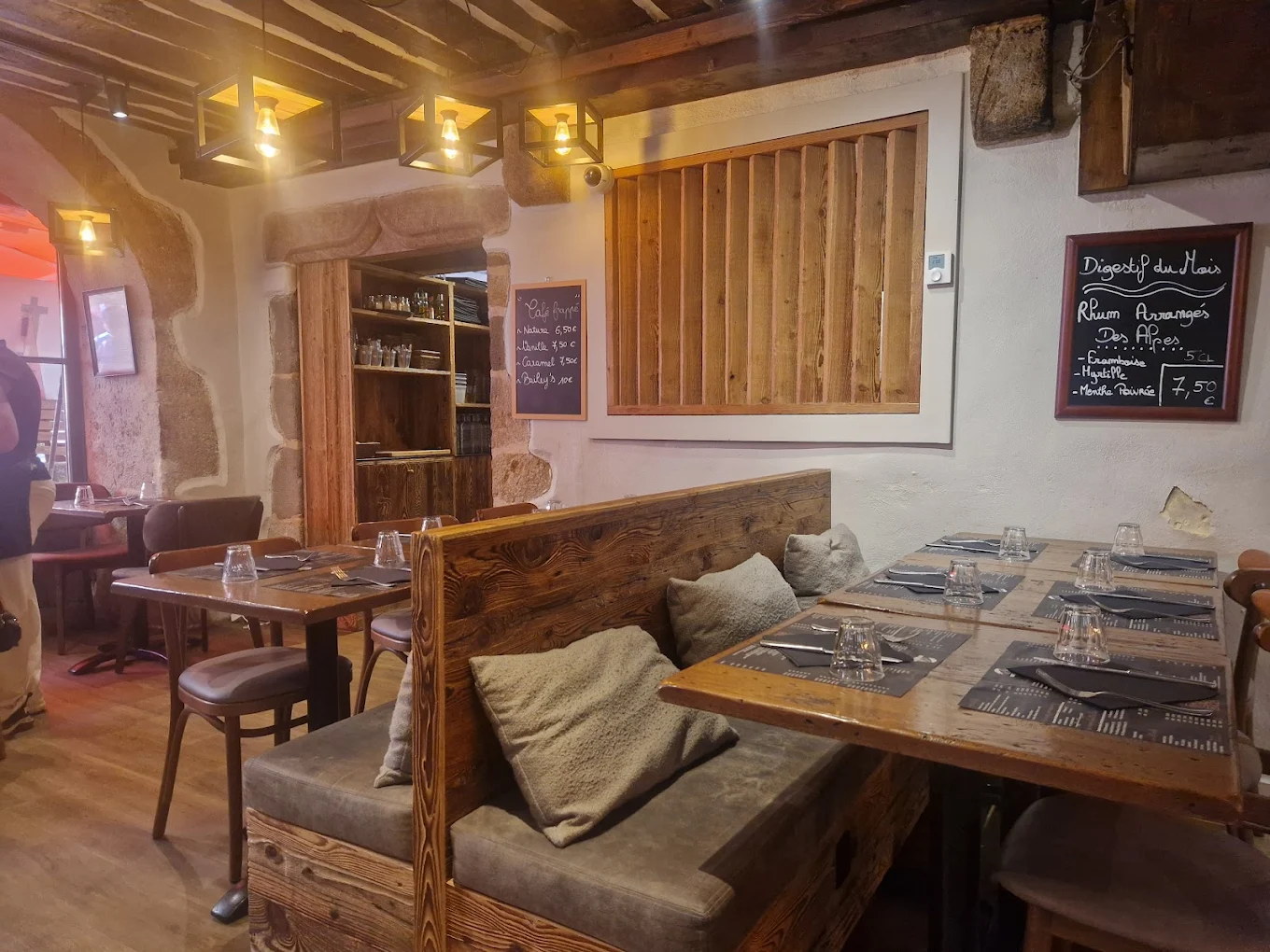 La salle du Zinc à Raoul : plafond de bois, tableau noir et tables dressées.